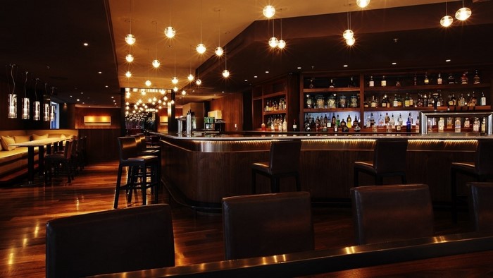 Interior of a modern bar with seating and liquor shelves