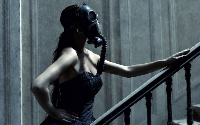 Woman in Black Dress Wearing Gas Mask on Staircase