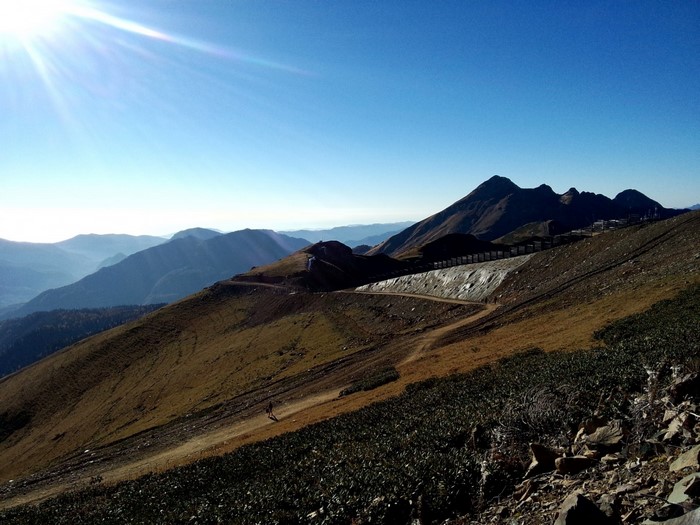 Mountain range with sunlit sky and hiking path