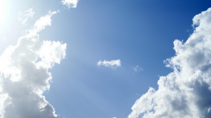Blue sky with white cumulus clouds and sunlight