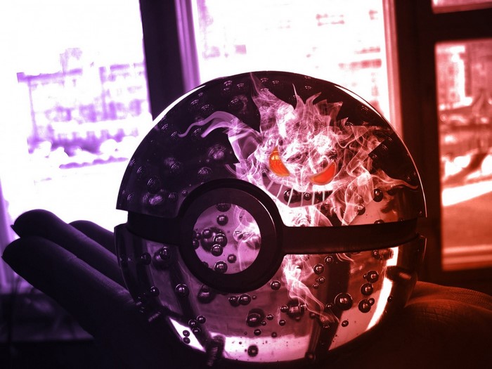 Gengar reflected in a Pokeball held in a hand