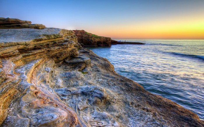 Rocky coastline at sunset with ocean waves