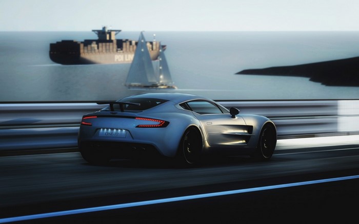 Aston Martin One 77 driving by the sea with a ship