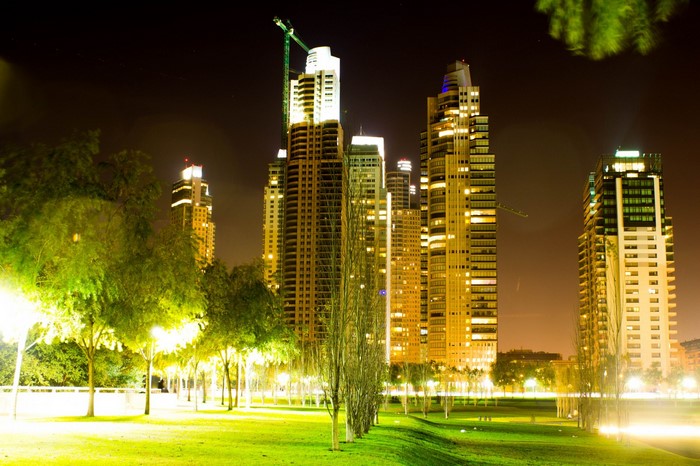 Cityscape with skyscrapers and park at night