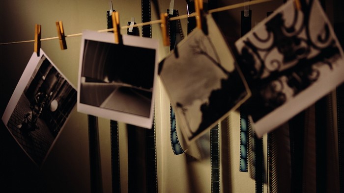 Photographs and film strips hanging on a line