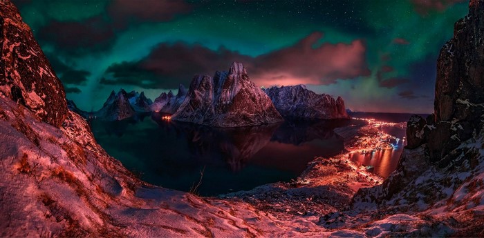 Mountains and Aurora Borealis over a Coastal Town