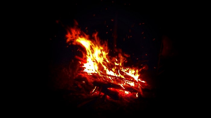 Campfire burning at night with sparks
