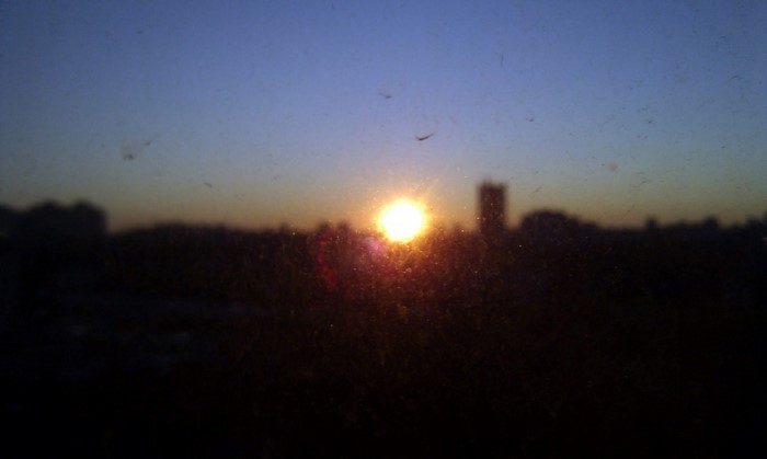Sunset over a blurry cityscape with sun in the center