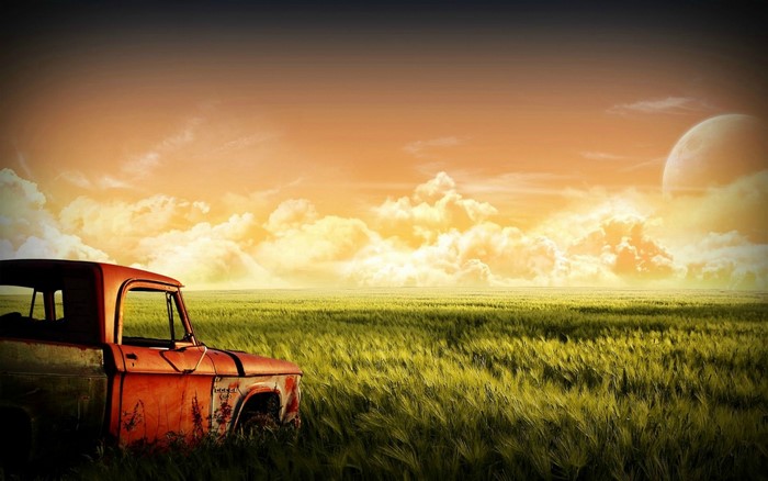 Old rusty truck in a field at sunset