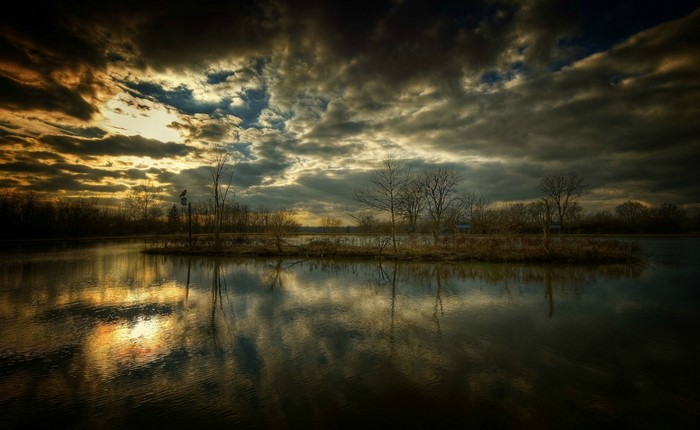 Dramatic sunset over a calm lake with reflections