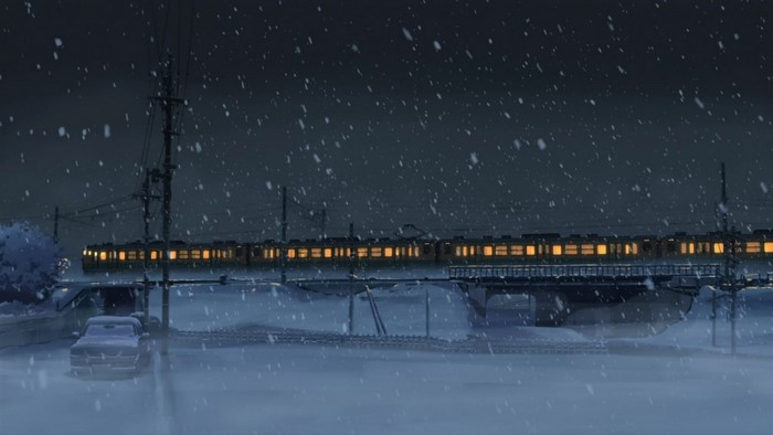 Train crossing a bridge in the snow at night