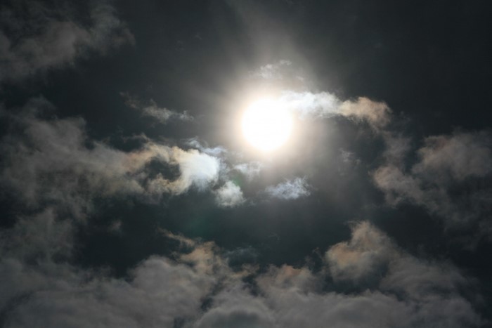 Sun shining through dark clouds