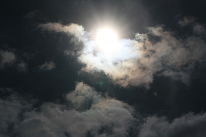 Sunlight shining through dark clouds in the sky
