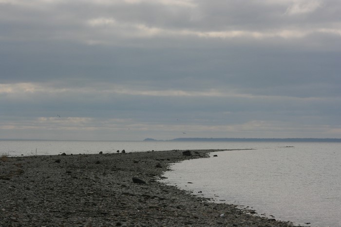 Overcast sky over a rocky shore and calm sea