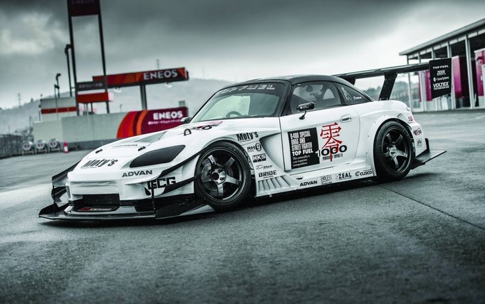 White Honda S2000 with racing decals on a track