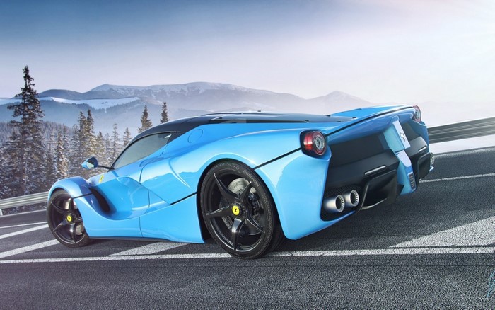 Blue Ferrari LaFerrari driving on a road with mountains