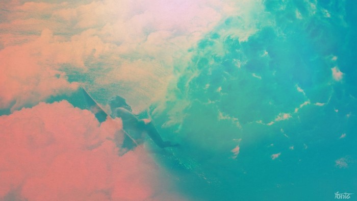 Surfer in clouds with sunlight and waves