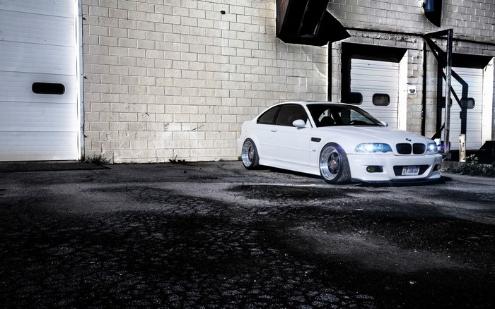 White BMW M3 E46 parked by a brick building