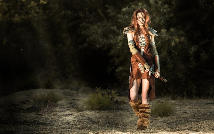 Woman in Skyrim cosplay with sword in forest