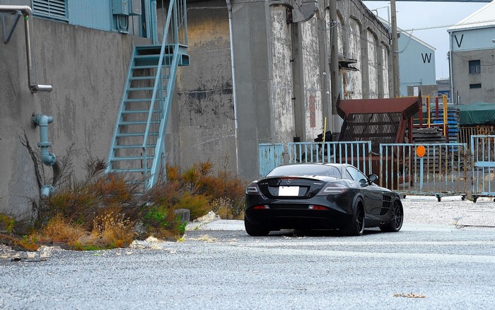 Black Mercedes-Benz SLR McLaren parked on wet asphalt
