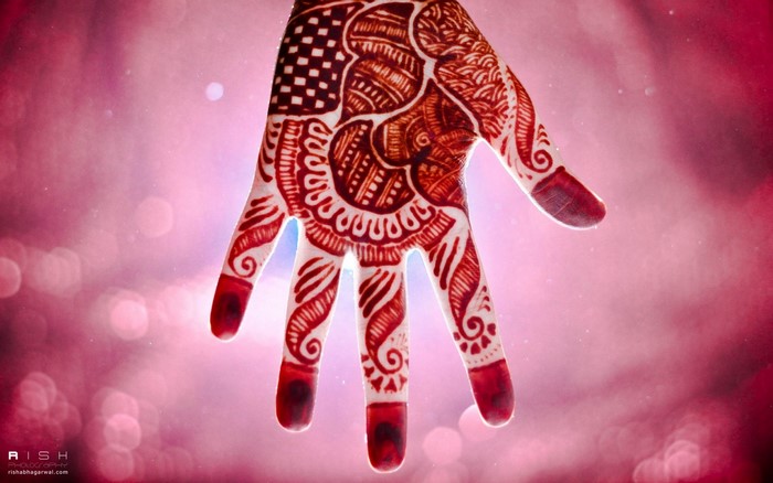 Close up of a hand with henna tattoo and bokeh background
