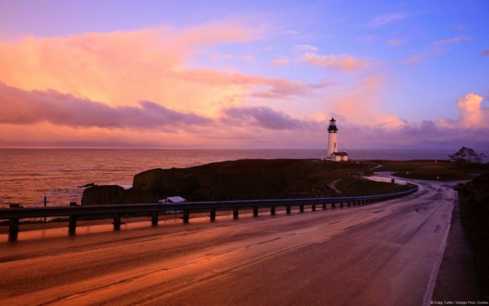 Serene Coastal Road Leading to a Lighthouse at Sunset
