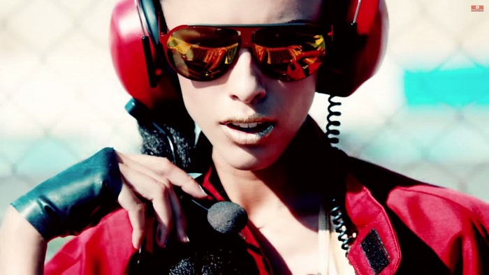Woman with headphones and sunglasses holding a microphone