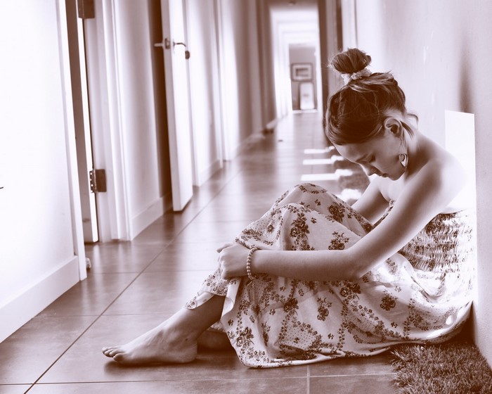 Woman in a floral dress sitting on the floor