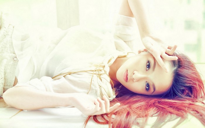 Asian woman with dyed red hair lying down
