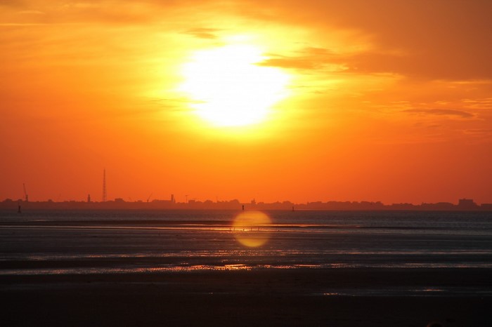 Sunset over the sea with city skyline