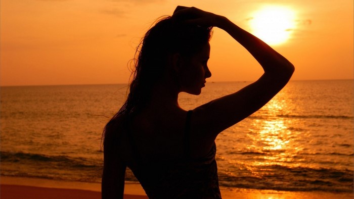 Silhouette of a woman at sunset on a beach