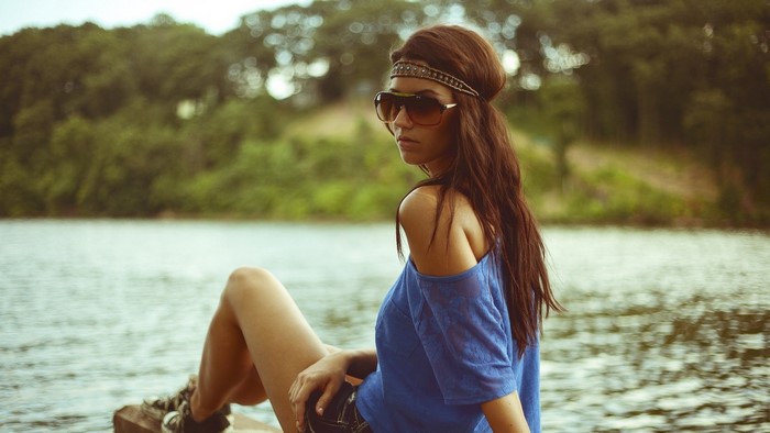 Woman with sunglasses and headband by the water