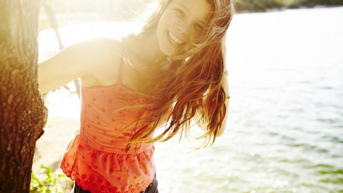Young woman with long hair smiling outdoors