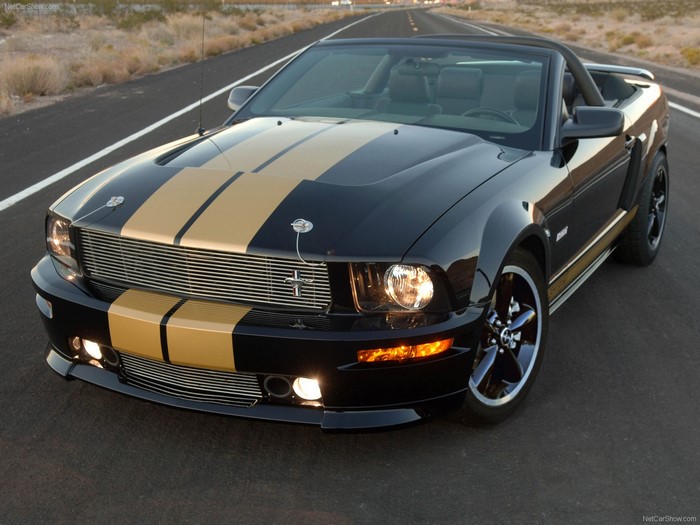 Black Ford Mustang Convertible with Gold Stripes on Road