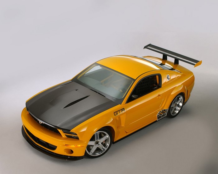 Yellow Ford Mustang GTR with a black hood and spoiler