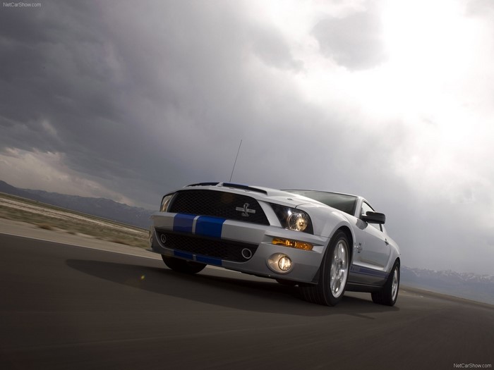 Silver Ford Shelby Mustang GT500 driving on a road