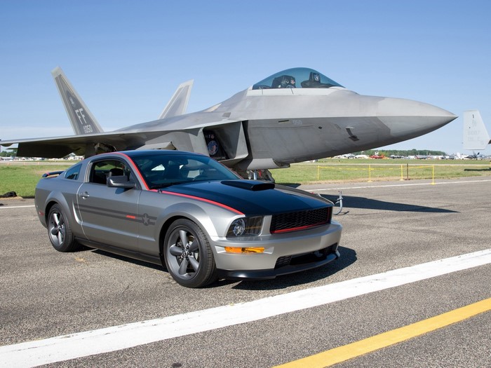 Silver Ford Mustang GT parked next to a fighter jet
