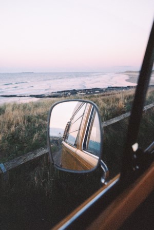 View of the sea through a car's rearview mirror