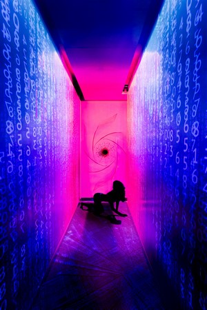 Silhouette of a woman in a neon hallway with digital code