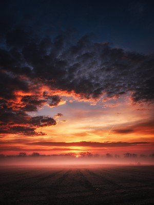 Dramatic sunset over a misty field