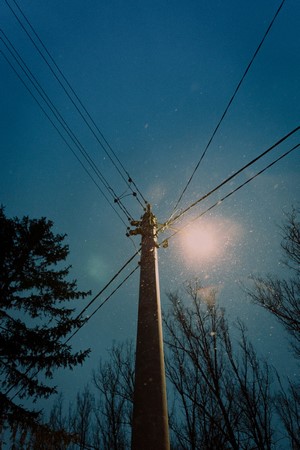 Power lines against a snowy blue sky