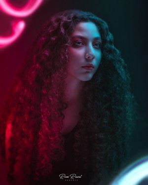 Woman with curly hair illuminated by neon lights