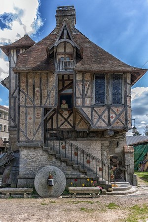 Old timber-framed building with a millstone in France