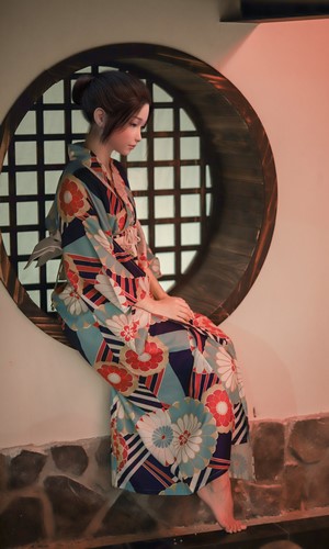 Woman in a traditional Japanese kimono sitting by a window