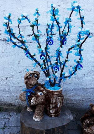 Decorative tree with evil eye charms and turtle figurine