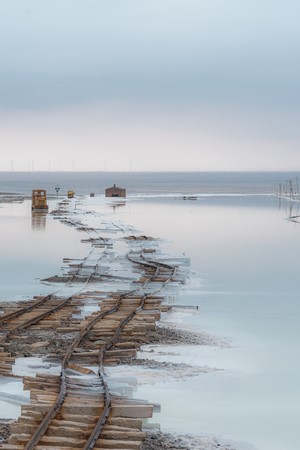 Flooded train tracks leading to buildings in water