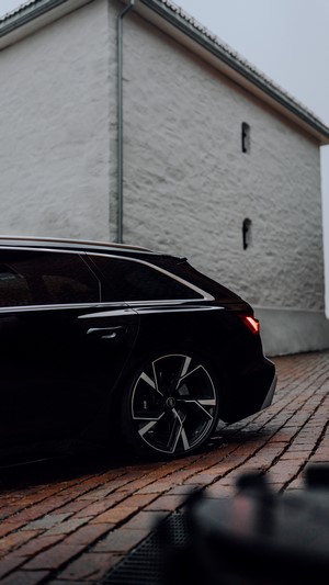 Black Audi RS6 Avant parked on cobblestone street
