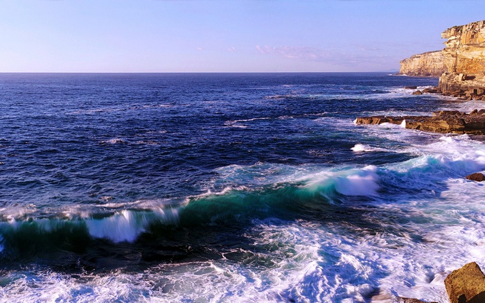 Waves crashing on rocky cliffs by the ocean