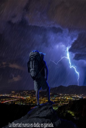 Hiker on a mountain during a thunderstorm with lightning