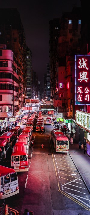 Busy Hong Kong street at night with red buses